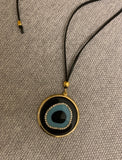 Long adjustable leather rope holding a large EvilEye pendant