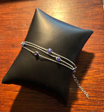 Triple chain bracelet containing dark blue eyes.